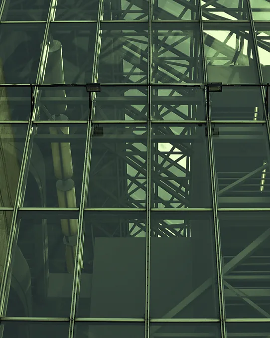 A steel and glass lattice seen through a curtain wall